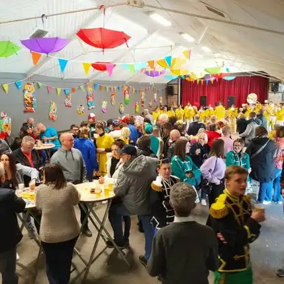 La salle communale décorée de parapluies colorés, remplie de monde pendant le carnaval